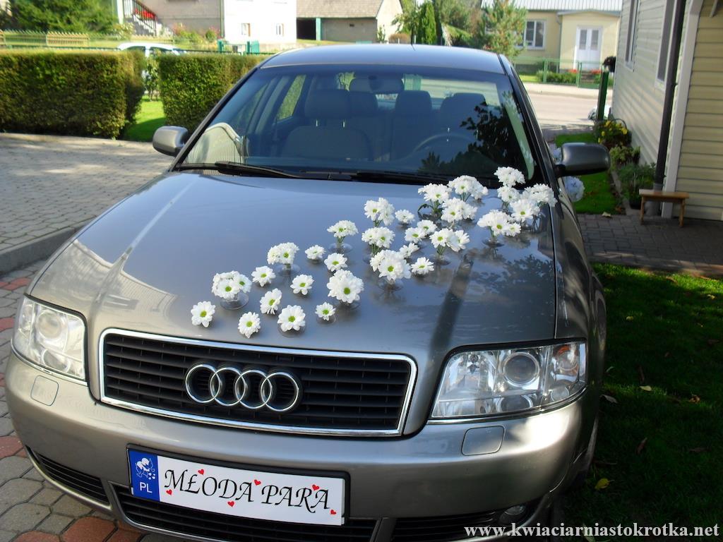 Samochód udekorowany subtelną girlandą kwiatową
